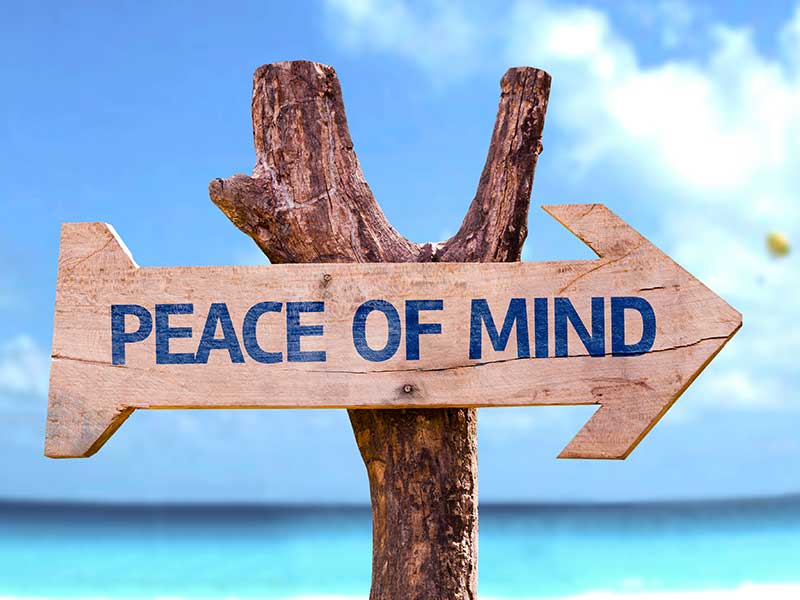 Wooden sign on a beach with 'Peace Of Mind' written on it
