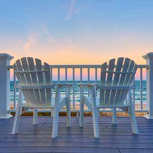 Two beach chairs on porch deck looking out at ocean